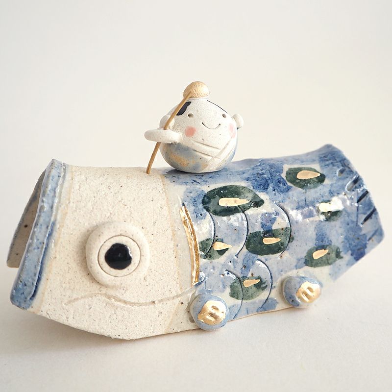 手にサオを持った男の子のお人形が乗っています