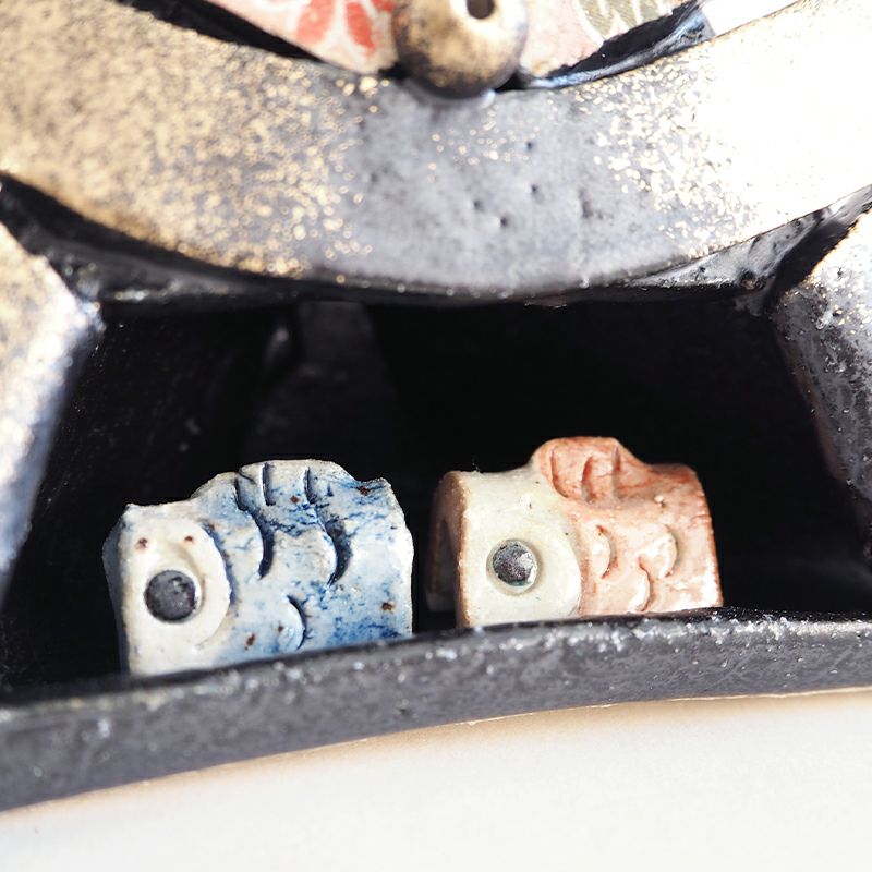 兜の中に2匹の鯉が入っています