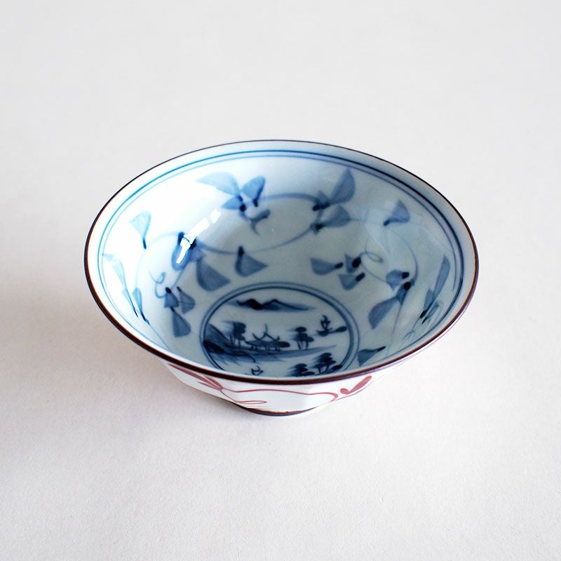 手描きの唐草模様と内側に山水が描かれた飯碗です