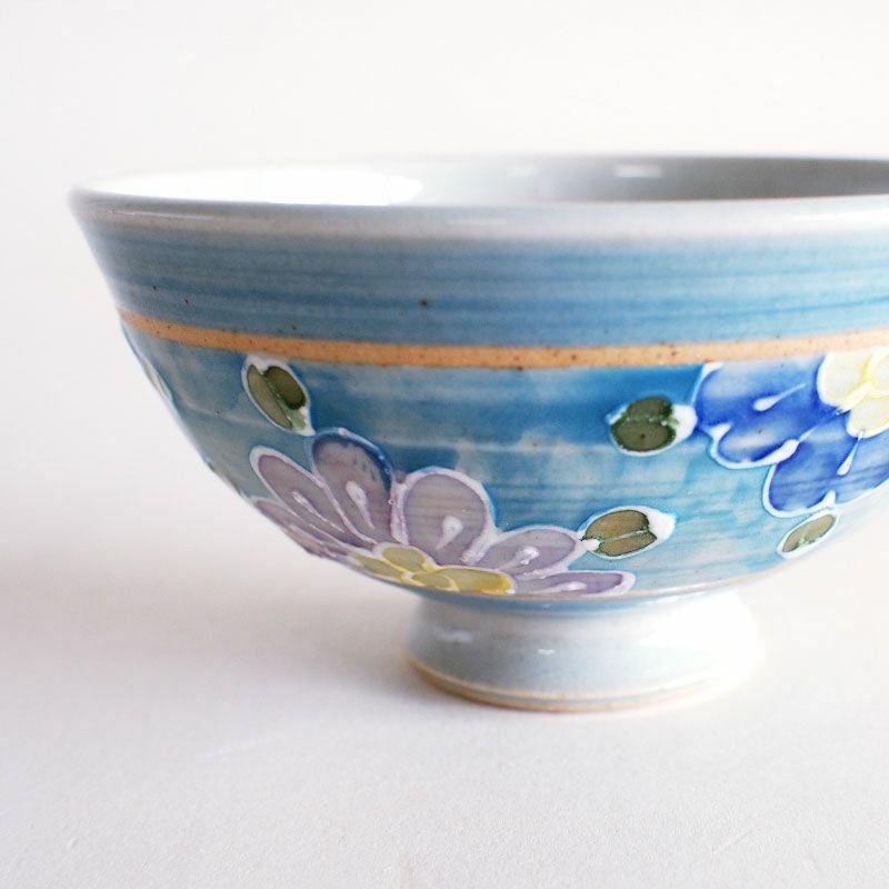 絞り出した釉薬で花柄の輪郭を描いています