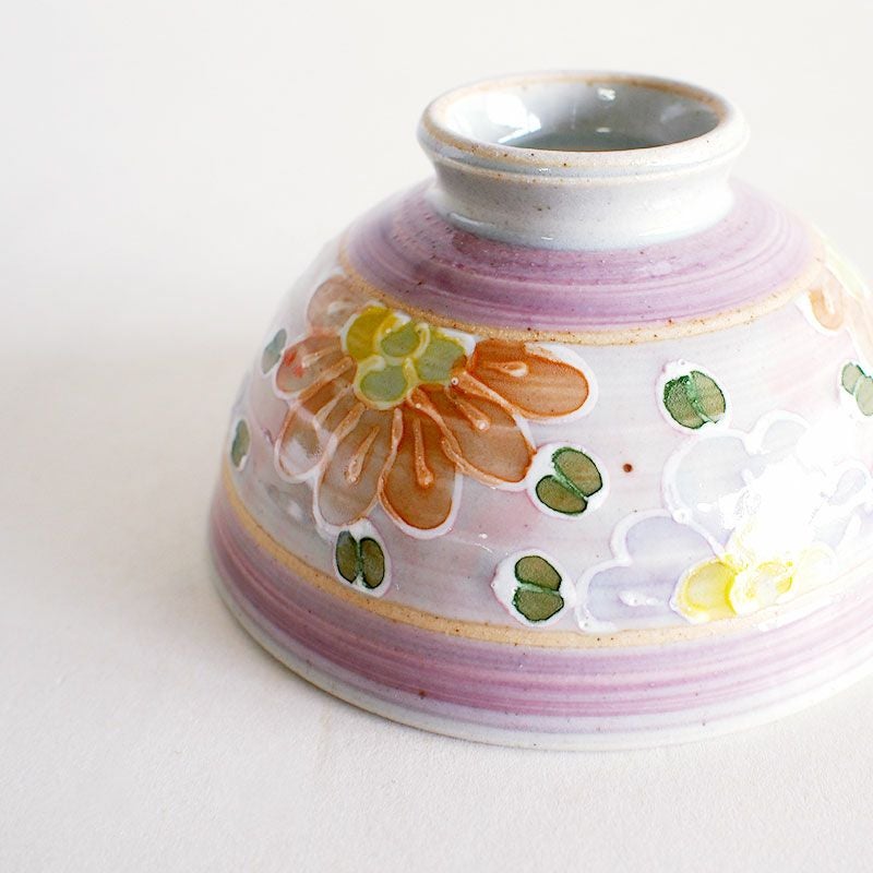 絞り出した釉薬で花柄の輪郭を描いています