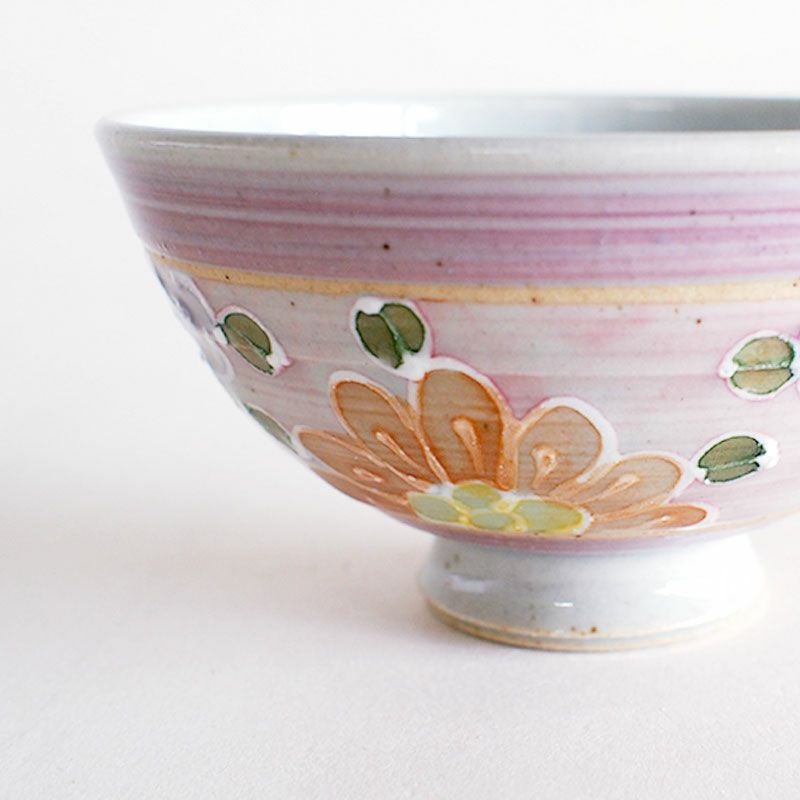 絞り出した釉薬で花柄の輪郭を描いています