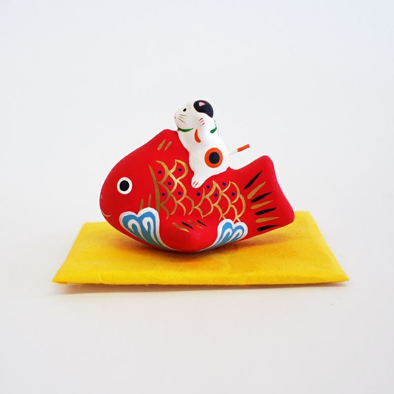 縁起のよい鯛の上にちょこんと乗ったはみけ猫がかわいい